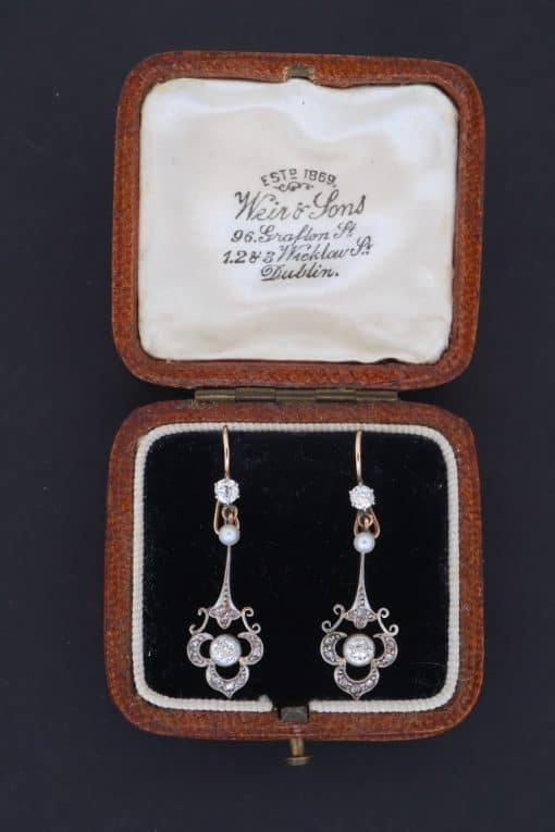 A beautiful pair of antique Belle Époque diamond and pearl drop earrings, dating to circa 1910. Elegant and refined, they capture the graceful femininity of the period, when delicate diamond jewellery and the soft lustre of pearls were particularly fashionable.