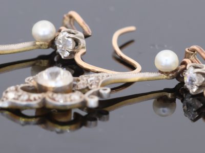 A beautiful pair of antique Belle Époque diamond and pearl drop earrings, dating to circa 1910. Elegant and refined, they capture the graceful femininity of the period, when delicate diamond jewellery and the soft lustre of pearls were particularly fashionable.