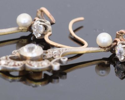 A beautiful pair of antique Belle Époque diamond and pearl drop earrings, dating to circa 1910. Elegant and refined, they capture the graceful femininity of the period, when delicate diamond jewellery and the soft lustre of pearls were particularly fashionable.