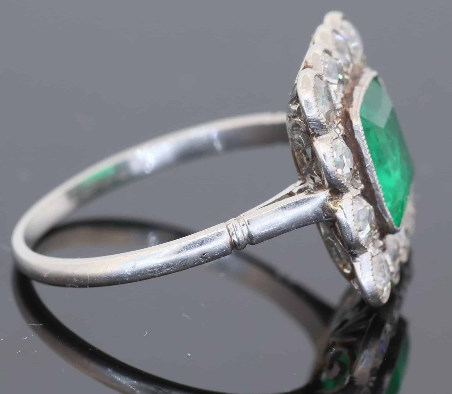 A superb Edwardian emerald and diamond ring, dating to circa 1905 and set in platinum. At its centre is a magnificent 1.5-carat step-cut emerald, distinguished by its exceptional colour and framed by a graceful surround of antique-cut diamonds. The combination of vivid emerald and the cool brilliance of platinum is quintessentially Edwardian, creating a jewel of considerable elegance and character.
