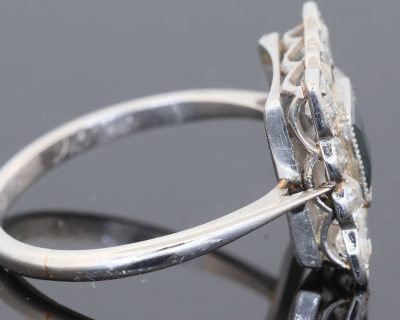 A charming antique sapphire and diamond cluster ring, dating to circa 1923, set in platinum and carrying a wonderfully personal inscription inside the shank: “FHB to Gwen 1923”. The dated dedication gives this elegant jewel a tangible connection to its original owners, transforming it from a beautiful piece of jewellery into a small piece of personal history. The inscription suggests that the ring was presented to Gwen in 1923, making it particularly evocative as a period gift.