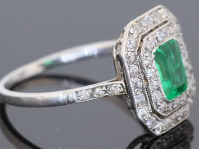 A beautiful Belle Époque emerald and diamond cluster ring, made in France circa 1910 and showcasing the period’s love of delicate platinum construction, fine diamonds and richly coloured gemstones. At its centre is a superb 1-carat Colombian emerald, surrounded by a double halo of diamonds that enhances the stone’s natural colour and gives the ring an elegant, balanced appearance.