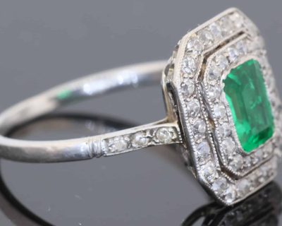 A beautiful Belle Époque emerald and diamond cluster ring, made in France circa 1910 and showcasing the period’s love of delicate platinum construction, fine diamonds and richly coloured gemstones. At its centre is a superb 1-carat Colombian emerald, surrounded by a double halo of diamonds that enhances the stone’s natural colour and gives the ring an elegant, balanced appearance.