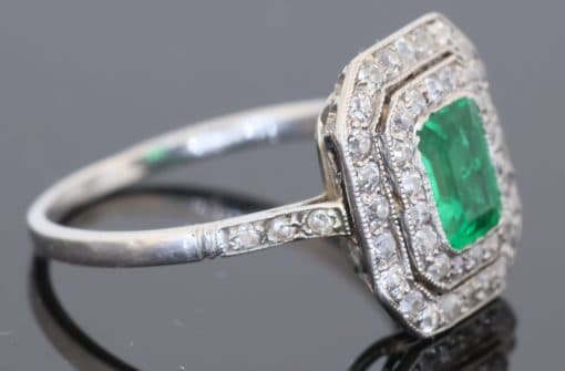 A beautiful Belle Époque emerald and diamond cluster ring, made in France circa 1910 and showcasing the period’s love of delicate platinum construction, fine diamonds and richly coloured gemstones. At its centre is a superb 1-carat Colombian emerald, surrounded by a double halo of diamonds that enhances the stone’s natural colour and gives the ring an elegant, balanced appearance.