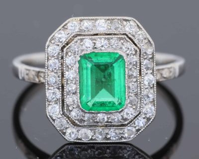 A beautiful Belle Époque emerald and diamond cluster ring, made in France circa 1910 and showcasing the period’s love of delicate platinum construction, fine diamonds and richly coloured gemstones. At its centre is a superb 1-carat Colombian emerald, surrounded by a double halo of diamonds that enhances the stone’s natural colour and gives the ring an elegant, balanced appearance.