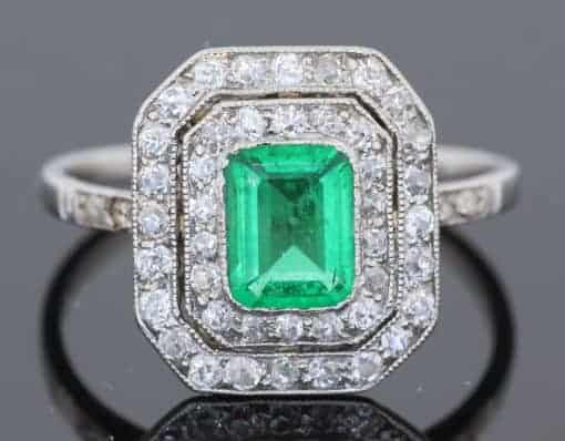 A beautiful Belle Époque emerald and diamond cluster ring, made in France circa 1910 and showcasing the period’s love of delicate platinum construction, fine diamonds and richly coloured gemstones. At its centre is a superb 1-carat Colombian emerald, surrounded by a double halo of diamonds that enhances the stone’s natural colour and gives the ring an elegant, balanced appearance.