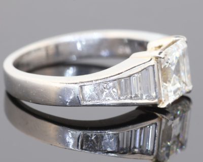 A superb diamond ring distinguished by the striking geometry of a rare carré-cut diamond. Celebrated for its clean lines and architectural elegance, the carré cut brings a distinctive character to this exceptional design, beautifully complemented by the precision and sparkle of its accompanying diamonds.