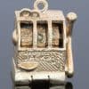 A wonderfully whimsical gold novelty charm in the form of a one-armed bandit, capturing the playful spirit of traditional gambling machines in miniature. The charm is particularly appealing for its working mechanism, transforming an instantly recognisable slot machine into an ingenious piece of novelty jewellery.