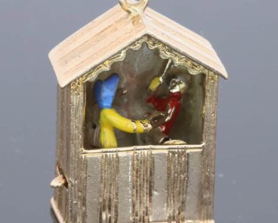 An extremely rare and wonderfully whimsical large gold charm depicting a Punch & Judy show, capturing the theatrical character and humour of one of Britain’s most enduring forms of popular entertainment. Punch & Judy performances have long been associated with seaside resorts, fairs and street entertainment, making this an especially charming subject for a piece of jewellery. The remarkable mechanical element makes the charm particularly unusual and collectible.