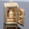 A charming and unusual gold novelty safe charm, designed as a miniature representation of a traditional safe and incorporating a delightful hidden surprise. Novelty charms of this kind transformed familiar objects into miniature works of jewellery, often with an element of humour or concealed detail. This example is particularly appealing for its clever association between a safe and its precious contents.