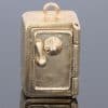A charming and unusual gold novelty safe charm, designed as a miniature representation of a traditional safe and incorporating a delightful hidden surprise. Novelty charms of this kind transformed familiar objects into miniature works of jewellery, often with an element of humour or concealed detail. This example is particularly appealing for its clever association between a safe and its precious contents.
