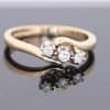 Elegant and distinctive, this three-stone twist ring combines the warm lustre of gold with a graceful, flowing design. The three-stone arrangement offers a timeless appeal, while the twisted form introduces a sense of movement and individuality.