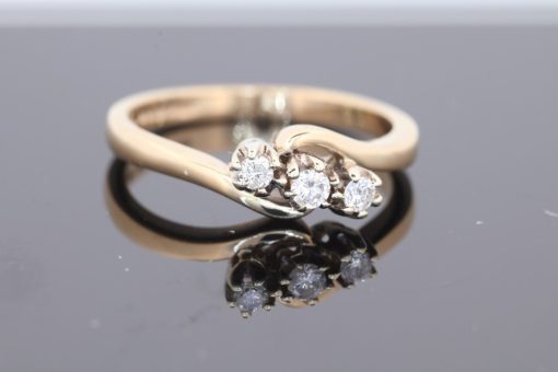 Elegant and distinctive, this three-stone twist ring combines the warm lustre of gold with a graceful, flowing design. The three-stone arrangement offers a timeless appeal, while the twisted form introduces a sense of movement and individuality.