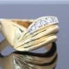 Distinctive and elegant, this wide diamond ring combines the warm lustre of gold with the brilliance of diamonds in an expressive, flowing design. Its unusual wave pattern gives the ring a sculptural quality, creating a piece that balances bold proportions with refined detailing.
