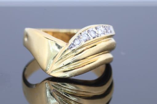 Distinctive and elegant, this wide diamond ring combines the warm lustre of gold with the brilliance of diamonds in an expressive, flowing design. Its unusual wave pattern gives the ring a sculptural quality, creating a piece that balances bold proportions with refined detailing.